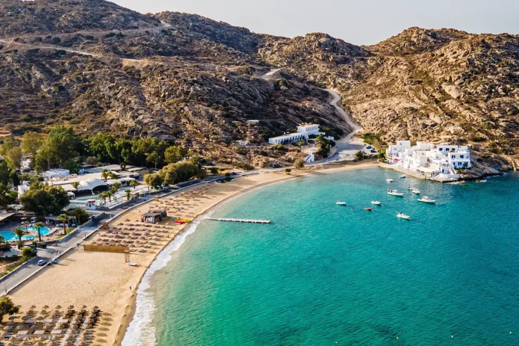 Aerial view of Mylopotas Beach in Ios, Greece, with turquoise water, golden sand and surrounding mountains