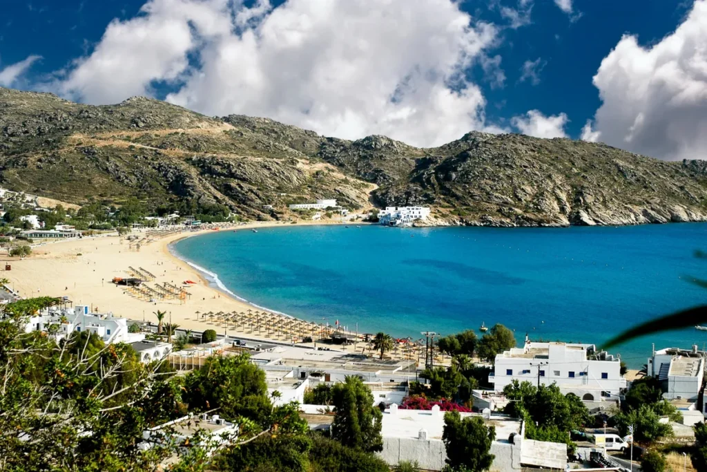 Mylopotas Beach in Ios, Greece, overlooking the turquoise Aegean Sea and surrounding mountains on the Harmony Ios Travel Guide